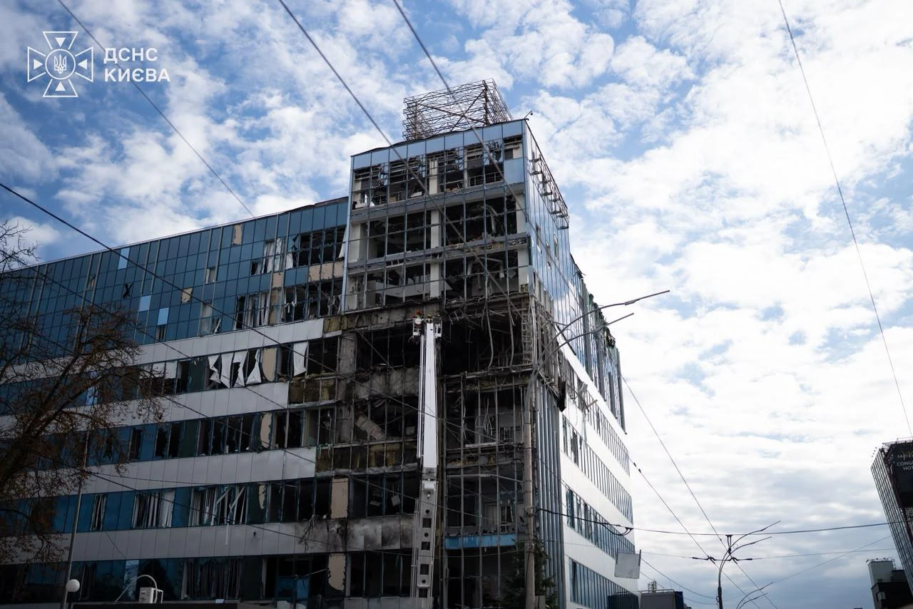 Наслідки дронового удару біля офісної будівлі в Солом'янському районі Києва, пошкоджений фасад, вибиті вікна, горівші автівки